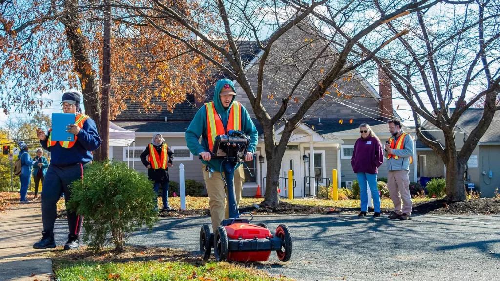 Students scan land to identify unmarked graves.